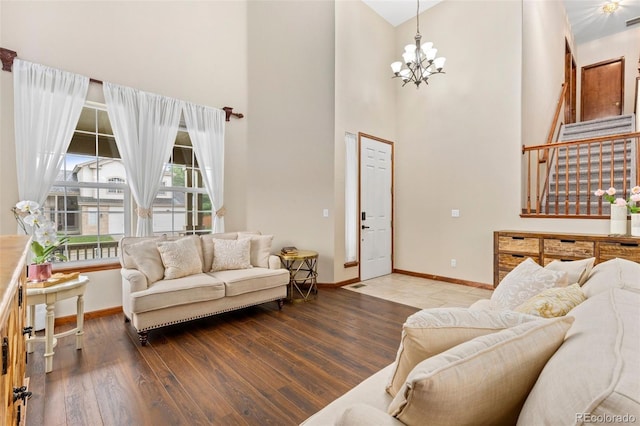 1831 Ashford Cir, Longmont, CO 80504 - living room with a high ceiling, a chandelier, baseboards, and wood finished floors