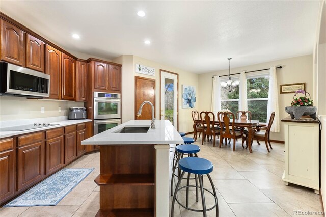 1831 Ashford Cir, Longmont, CO 80504 - kitchen with stainless steel appliances, a sink, light countertops, a breakfast bar, and recessed lighting
