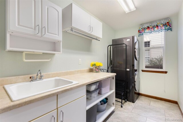 1831 Ashford Cir, Longmont, CO 80504 - kitchen featuring stacked washing machine and dryer, a sink, white cabinets, and light countertops