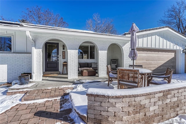 snow covered patio featuring a garage