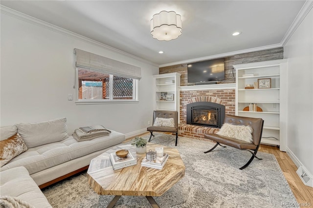 living room featuring a brick fireplace, crown molding, and light hardwood / wood-style flooring