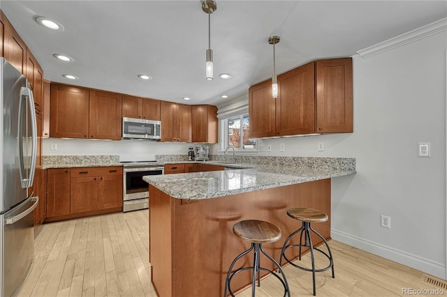 kitchen with light stone countertops, appliances with stainless steel finishes, decorative light fixtures, kitchen peninsula, and crown molding