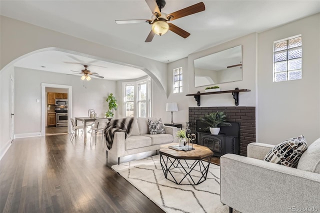 living room with ceiling fan, a healthy amount of sunlight, and dark hardwood / wood-style flooring