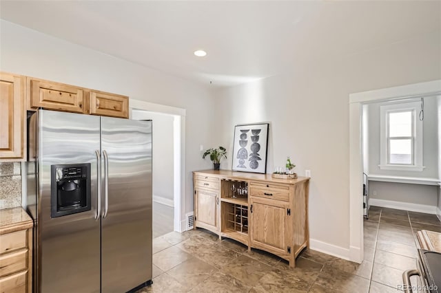 kitchen featuring tile patterned flooring, light brown cabinets, and stainless steel fridge