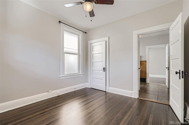 unfurnished bedroom featuring multiple windows, dark hardwood / wood-style floors, a closet, and ceiling fan