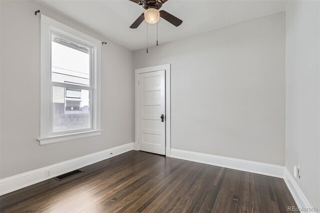 unfurnished room featuring dark wood-type flooring and ceiling fan