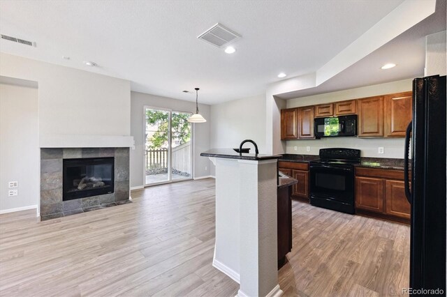 10480 Truckee St Unit B, Commerce City, CO 80022 - kitchen featuring black appliances, dark countertops, light wood-style flooring, open floor plan, and recessed lighting