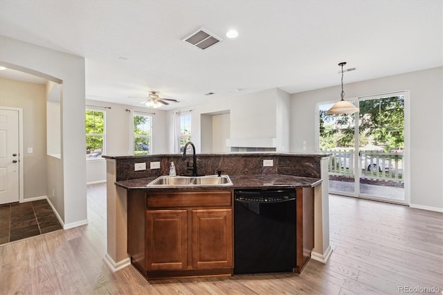 10480 Truckee St Unit B, Commerce City, CO 80022 - kitchen with black dishwasher, a kitchen island with sink, dark stone counters, pendant lighting, and backsplash