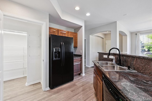 10480 Truckee St Unit B, Commerce City, CO 80022 - kitchen featuring black fridge with ice dispenser, dishwasher, light wood finished floors, arched walkways, and recessed lighting