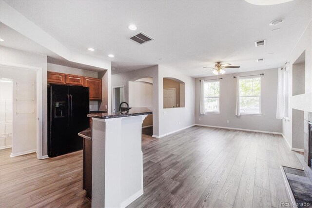 10480 Truckee St Unit B, Commerce City, CO 80022 - kitchen with black fridge, a ceiling fan, light wood finished floors, brown cabinetry, and recessed lighting