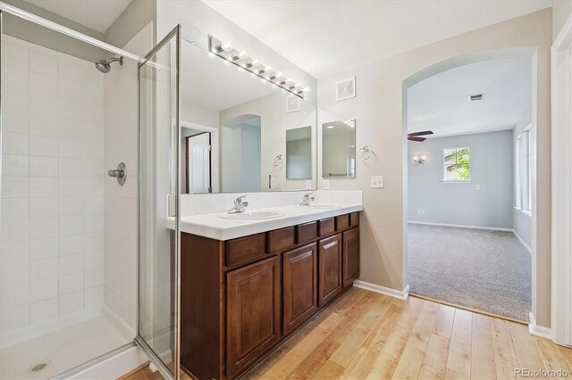 10480 Truckee St Unit B, Commerce City, CO 80022 - bathroom with double vanity, tiled shower, wood finished floors, and ceiling fan
