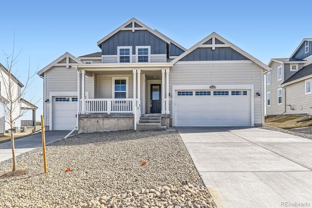 view of front of property with board and batten siding, covered porch, concrete driveway, and an attached garage