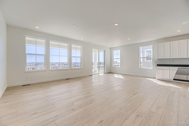 unfurnished living room featuring recessed lighting, visible vents, and light wood finished floors