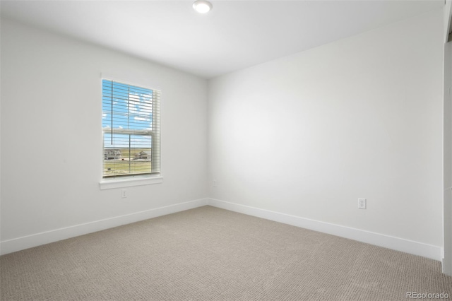 empty room with baseboards and light colored carpet