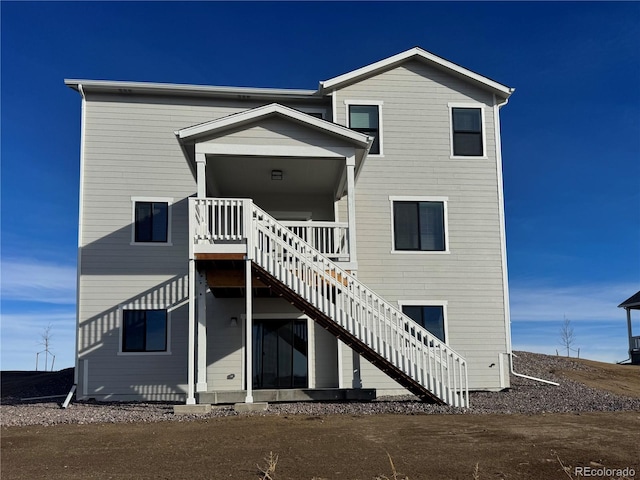 rear view of house featuring stairway and a wooden deck