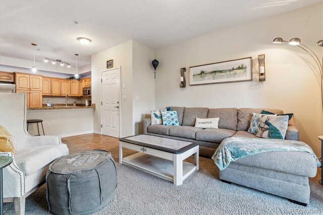living room featuring light tile patterned floors, rail lighting, and light colored carpet