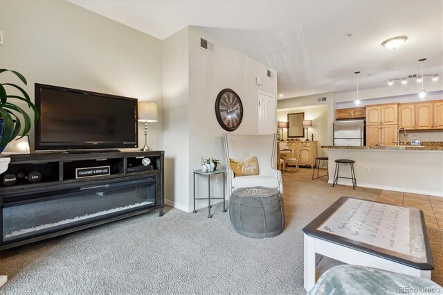 living room with visible vents, baseboards, and light colored carpet