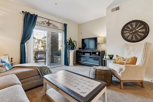 carpeted living area featuring visible vents and baseboards