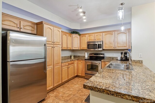 kitchen with a sink, light brown cabinets, and stainless steel appliances