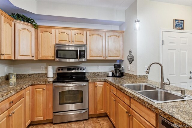 kitchen featuring a sink, appliances with stainless steel finishes, light brown cabinetry, and light tile patterned flooring