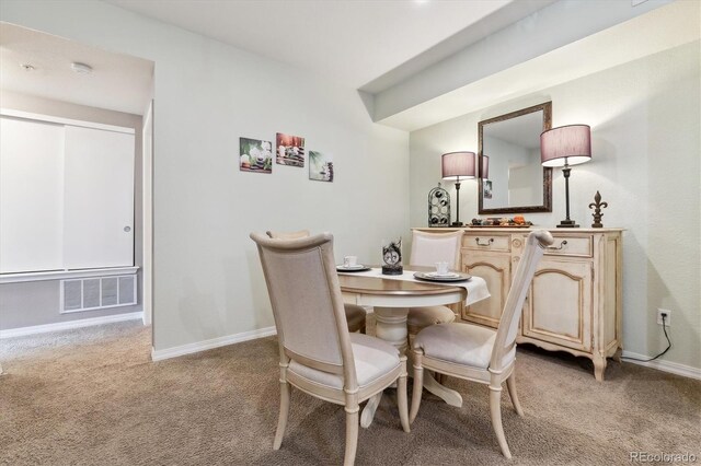 dining space featuring visible vents, baseboards, and light colored carpet