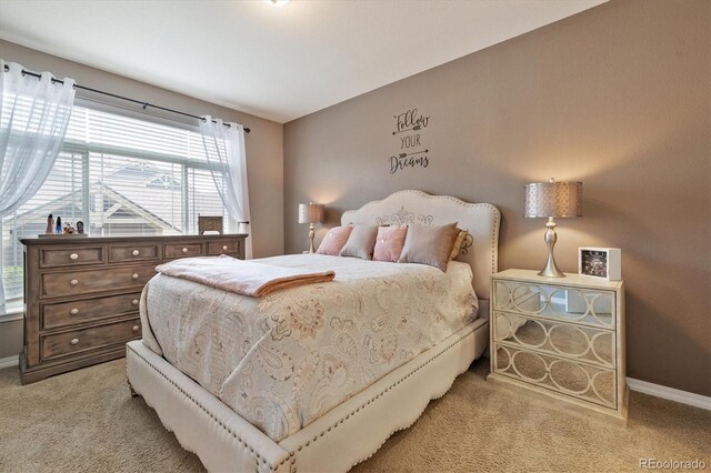 bedroom featuring baseboards and light colored carpet