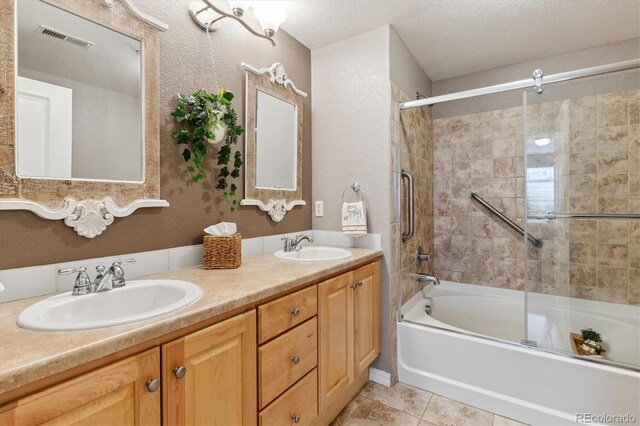 full bathroom with visible vents, a sink, double vanity, and shower / bath combination with glass door
