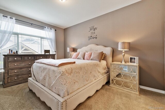 bedroom with baseboards and light carpet
