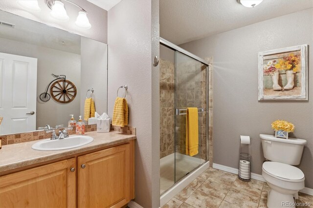 full bath featuring visible vents, a stall shower, toilet, and vanity
