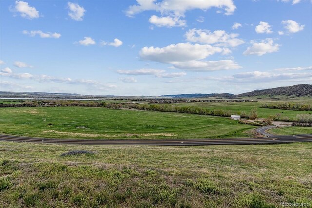surrounding community featuring a lawn, a mountain view, and a rural view