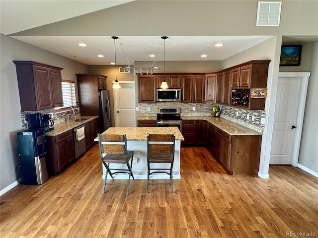 kitchen featuring visible vents, light wood-style flooring, appliances with stainless steel finishes, and a sink