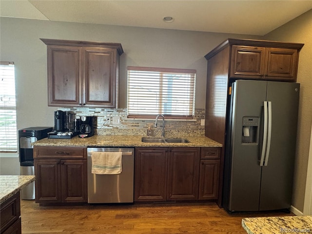 kitchen featuring a sink, dark wood-style flooring, stainless steel appliances, and tasteful backsplash