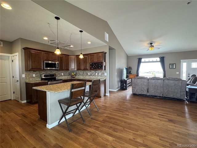 kitchen featuring backsplash, dark wood-style flooring, stainless steel appliances, and open floor plan