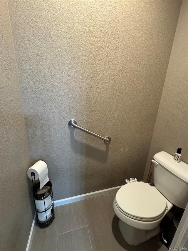 bathroom with toilet and baseboards