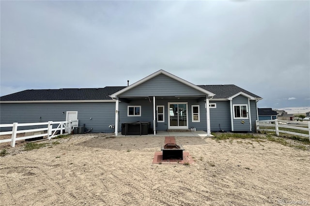 rear view of property with an outdoor fire pit, a patio, a fenced backyard, and cooling unit