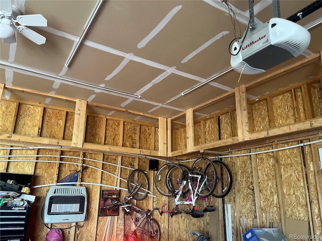 garage featuring heating unit, a ceiling fan, and a garage door opener