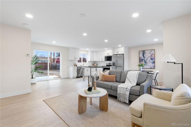 living room with sink and light wood-type flooring