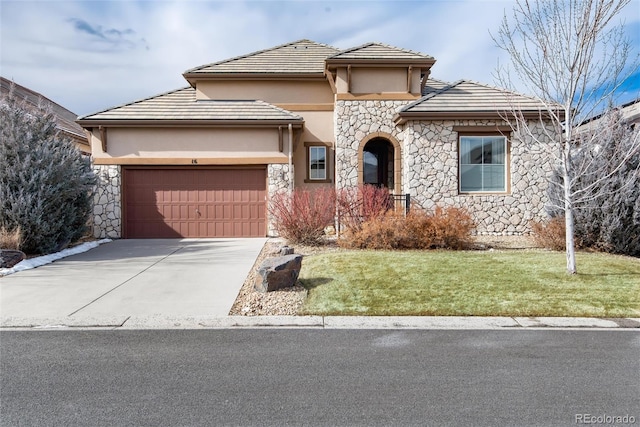 view of front of house with concrete driveway, stone siding, an attached garage, a front lawn, and stucco siding