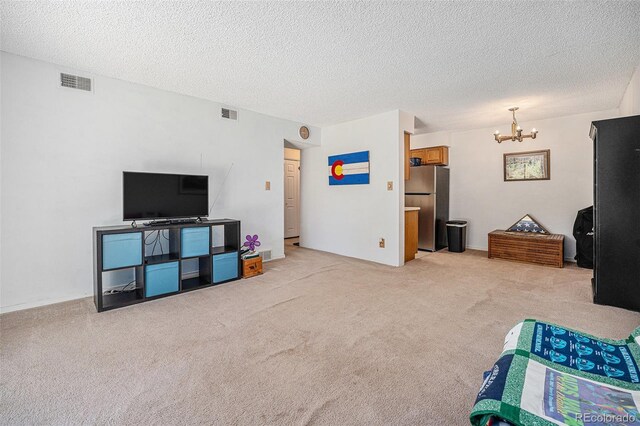 309 E Highline Cir Unit 102, Centennial, CO 80122 - living area featuring a chandelier, light carpet, and a textured ceiling