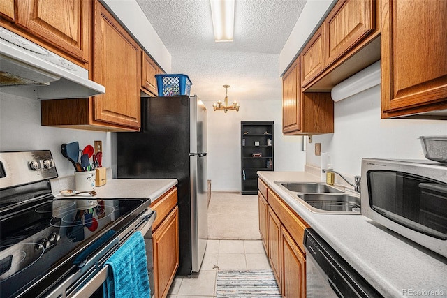 309 E Highline Cir Unit 102, Centennial, CO 80122 - kitchen featuring appliances with stainless steel finishes, under cabinet range hood, brown cabinetry, a chandelier, and light countertops