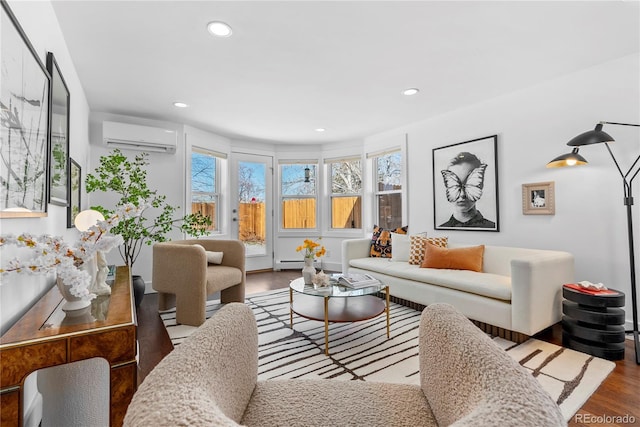 living room featuring a wall unit AC, a wealth of natural light, and hardwood / wood-style floors