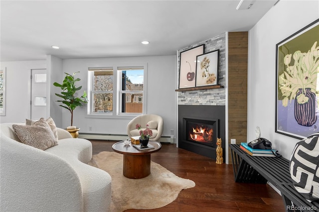 living room with baseboard heating, a fireplace, and dark wood-type flooring