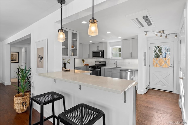 kitchen with kitchen peninsula, stainless steel appliances, and a breakfast bar area