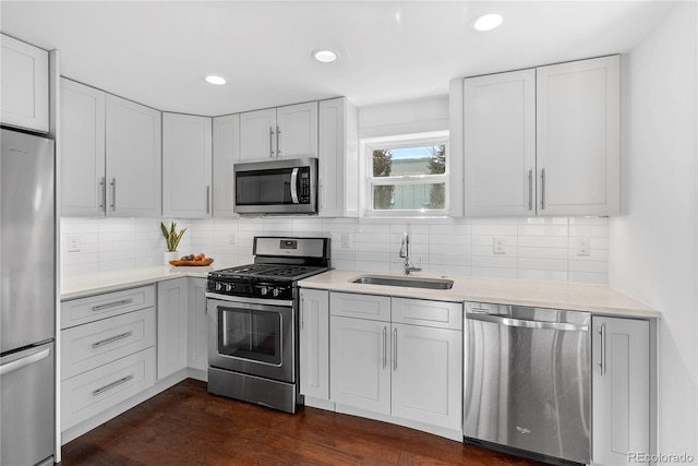 kitchen featuring tasteful backsplash, sink, dark wood-type flooring, and appliances with stainless steel finishes