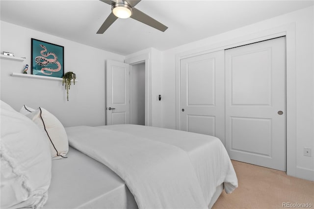 carpeted bedroom with ceiling fan and a closet