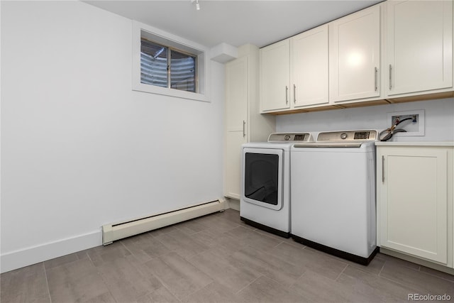 washroom with washer and dryer, cabinets, and a baseboard radiator