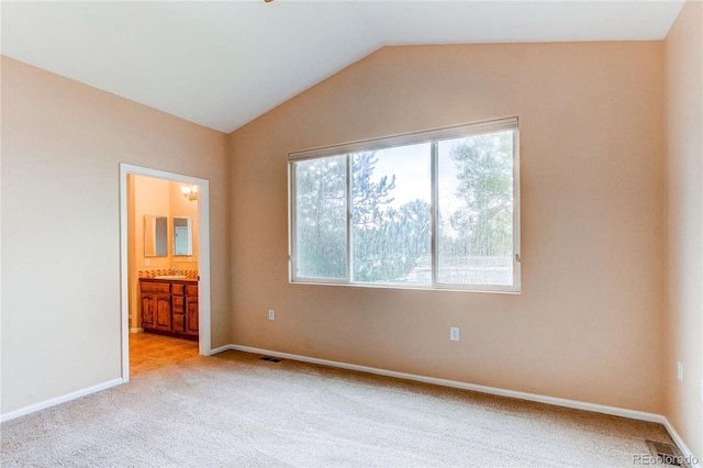 107 Carina Cir, Loveland, CO 80537 - unfurnished bedroom featuring vaulted ceiling, light colored carpet, baseboards, ensuite bath, and a sink
