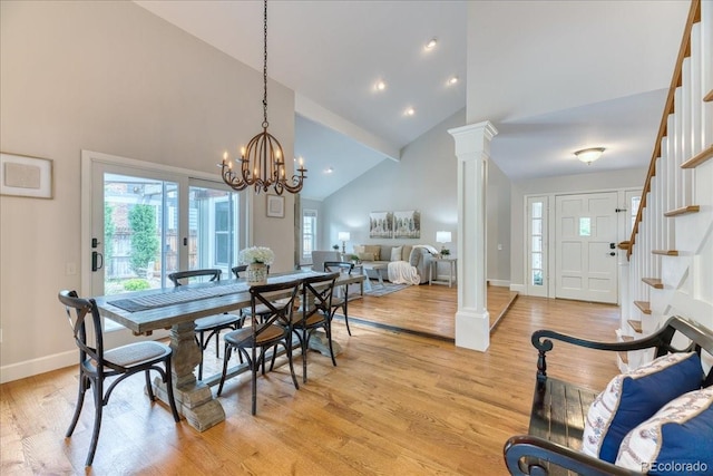 8167 S Wabash Ct, Centennial, CO 80112 - dining space with high vaulted ceiling, stairway, light wood-style flooring, decorative columns, and a chandelier