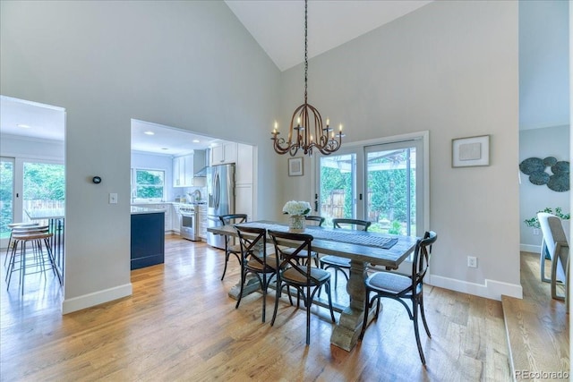8167 S Wabash Ct, Centennial, CO 80112 - dining area featuring light wood-style flooring, high vaulted ceiling, and a chandelier