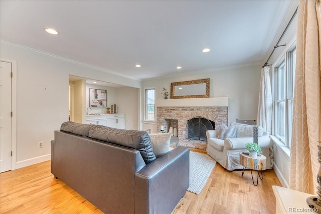 8167 S Wabash Ct, Centennial, CO 80112 - living area with light wood-type flooring, ornamental molding, a fireplace with raised hearth, and recessed lighting